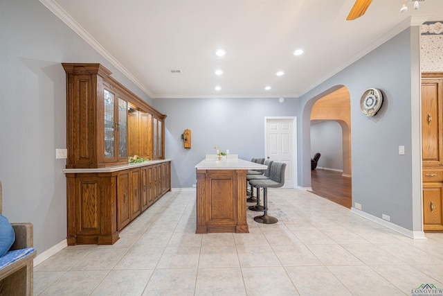 interior space featuring ceiling fan, light tile patterned floors, and crown molding