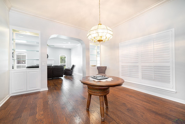 dining area featuring ornamental molding, ceiling fan with notable chandelier, and dark wood-type flooring