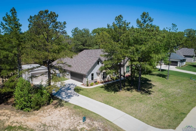 view of front of property featuring a garage, driveway, stone siding, roof with shingles, and a front yard