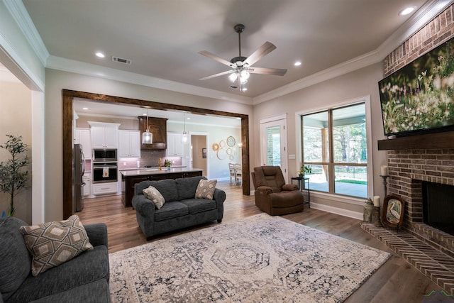 living room with light wood finished floors, visible vents, and ornamental molding