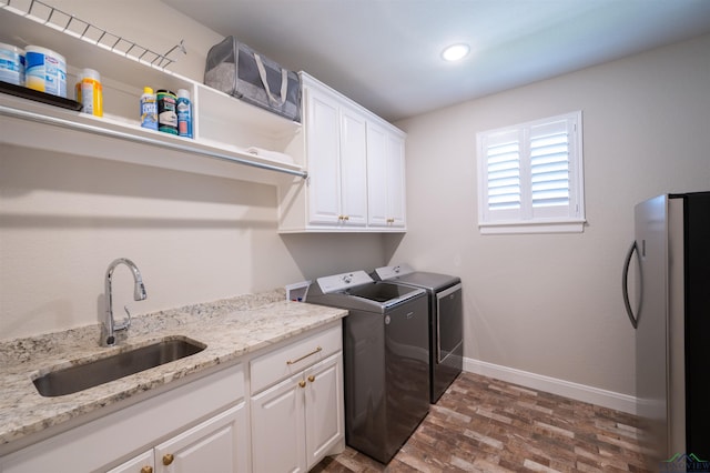 washroom with cabinet space, baseboards, separate washer and dryer, a sink, and recessed lighting