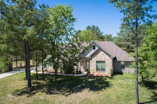 craftsman house with stone siding, roof with shingles, and a front lawn