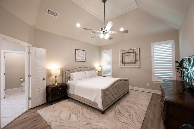 bedroom featuring baseboards, visible vents, connected bathroom, a ceiling fan, and vaulted ceiling