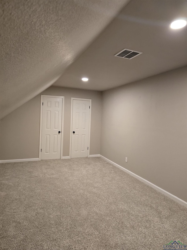 2013 E Warwick Cir, Longview, TX 75601 - additional living space with vaulted ceiling, carpet, recessed lighting, and a textured ceiling