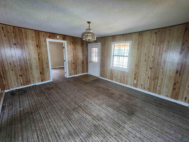 unfurnished room with a textured ceiling and an inviting chandelier