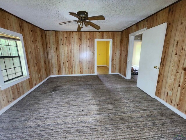 unfurnished room with ceiling fan and a textured ceiling