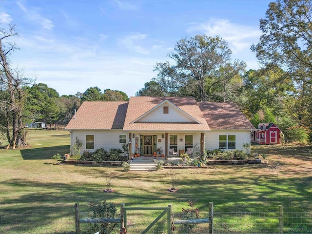 back of house with a lawn, a porch, and a storage shed