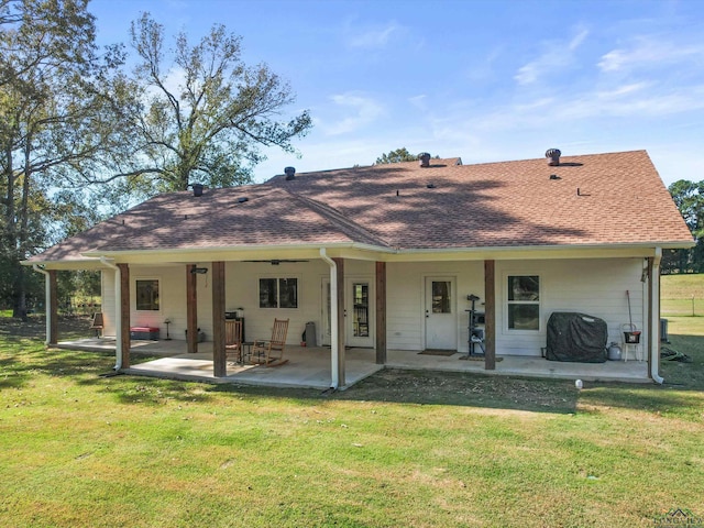 rear view of house with ceiling fan, a patio area, and a yard