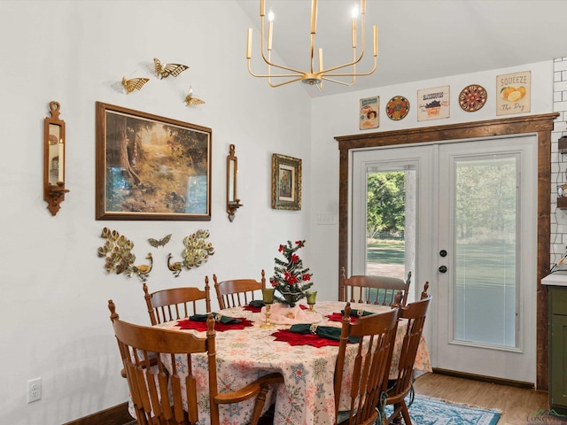 dining space featuring hardwood / wood-style floors, an inviting chandelier, and french doors