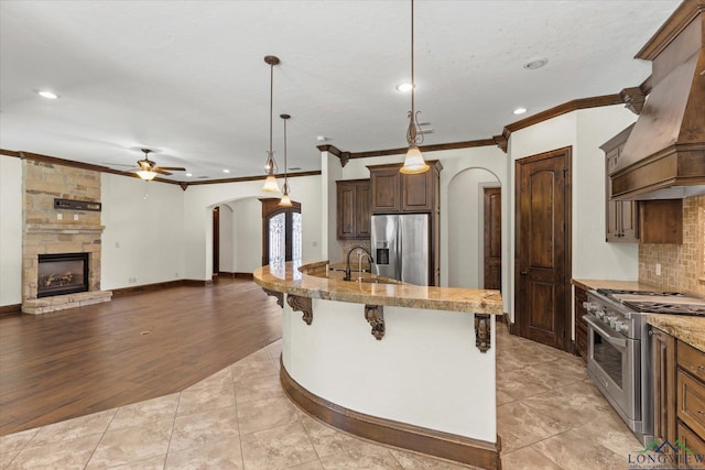 110 Rimrock Ln, Longview, TX 75605 - kitchen with arched walkways, appliances with stainless steel finishes, crown molding, custom range hood, and ceiling fan