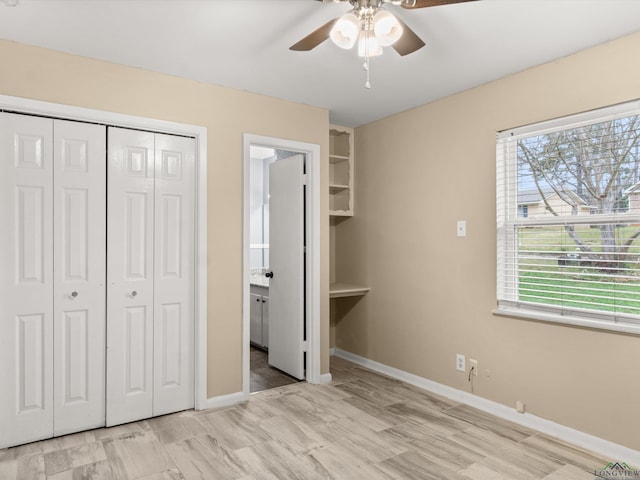 unfurnished bedroom with a closet, connected bathroom, a ceiling fan, and baseboards