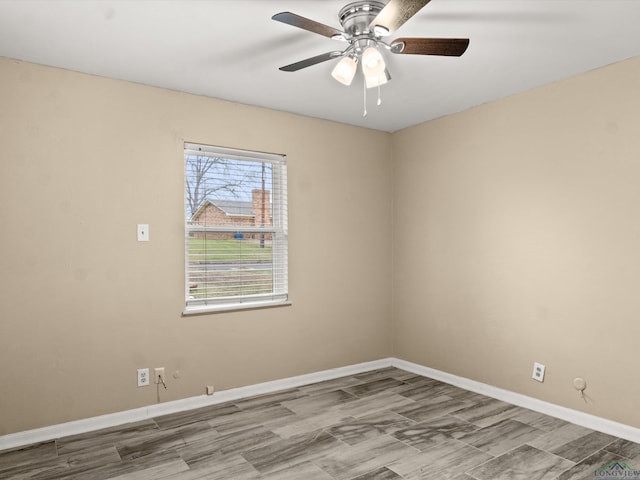 spare room featuring ceiling fan, baseboards, and wood finished floors