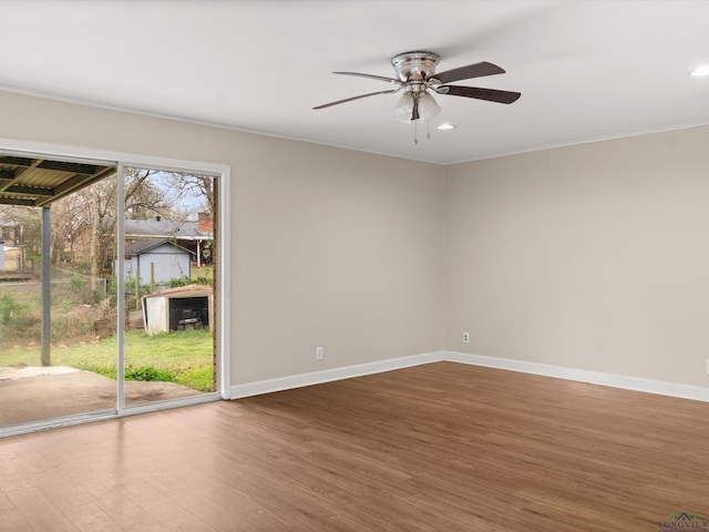 empty room with ceiling fan, baseboards, and wood finished floors