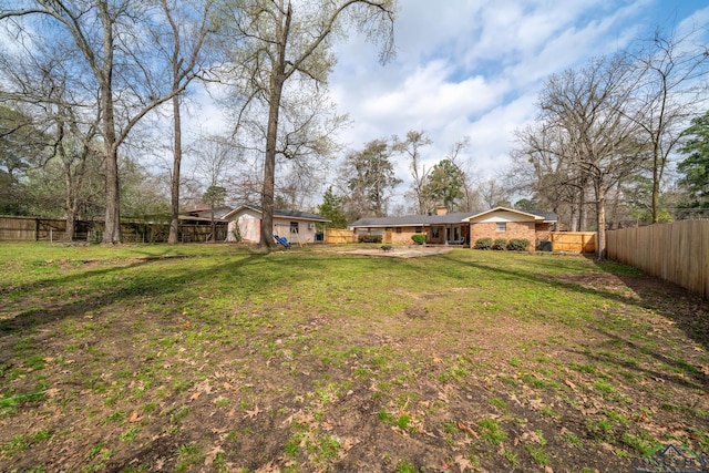 view of yard with an attached carport and a fenced backyard