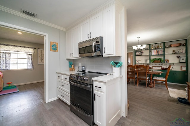 kitchen with stainless steel microwave, visible vents, light countertops, electric stove, and a notable chandelier