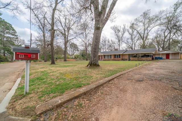 exterior space featuring an attached carport and dirt driveway