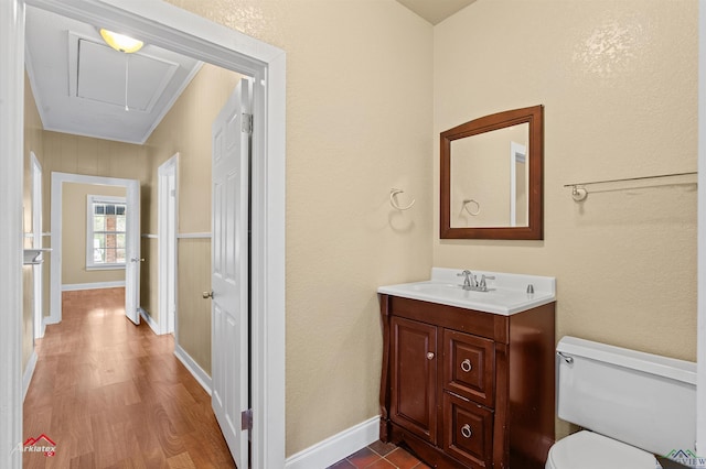 bathroom featuring baseboards, vanity, toilet, and wood finished floors