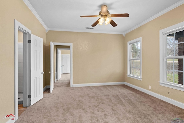 spare room with ornamental molding, baseboards, visible vents, and carpet flooring