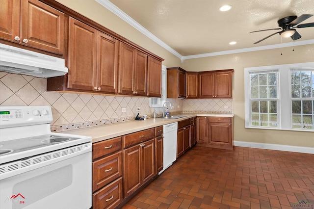 kitchen featuring brick floor, under cabinet range hood, white appliances, light countertops, and ornamental molding