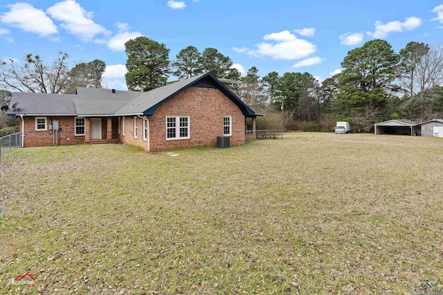 view of side of property featuring a carport, brick siding, a lawn, and fence