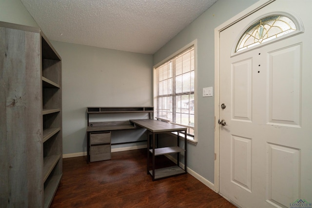 foyer entrance with dark hardwood / wood-style floors and a textured ceiling