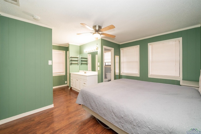 bedroom with ornamental molding, ensuite bathroom, ceiling fan, and dark hardwood / wood-style flooring