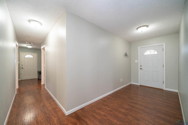 foyer entrance featuring dark hardwood / wood-style floors and a textured ceiling