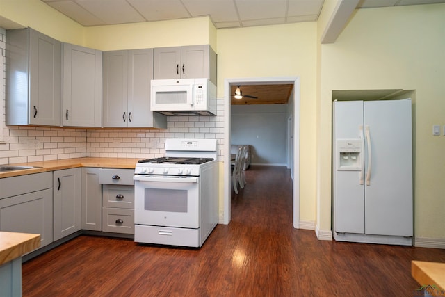 kitchen featuring wood counters, gray cabinetry, tasteful backsplash, dark hardwood / wood-style flooring, and white appliances