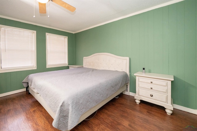 bedroom featuring dark hardwood / wood-style flooring, ornamental molding, and ceiling fan