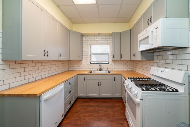 kitchen with butcher block counters, sink, white appliances, and gray cabinetry