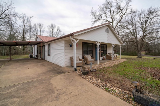 view of front of house featuring a carport, a front yard, and covered porch