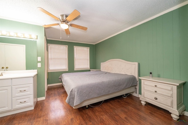 bedroom with dark hardwood / wood-style flooring, a textured ceiling, ornamental molding, and ceiling fan