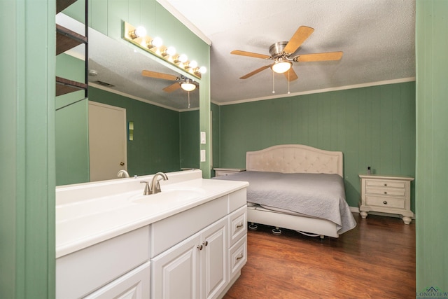 bedroom with sink, crown molding, dark wood-type flooring, ceiling fan, and a textured ceiling