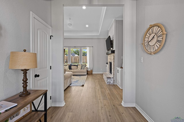 hall featuring light hardwood / wood-style flooring and a tray ceiling