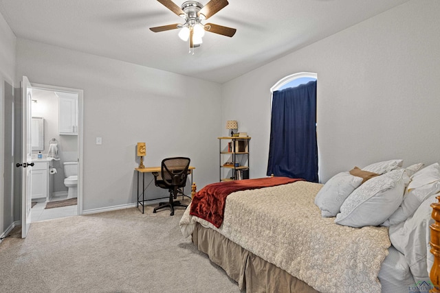 bedroom featuring light colored carpet, ceiling fan, and ensuite bathroom