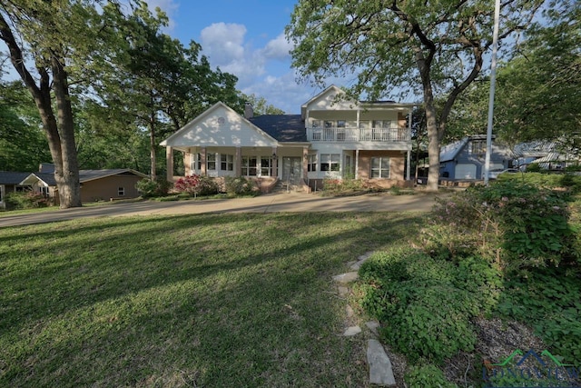 519 Hideaway Ln E, Hideaway, TX 75771 - view of front of house featuring a chimney, a front lawn, and a balcony