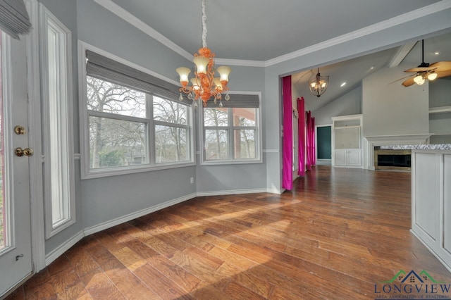 unfurnished dining area featuring wood-type flooring, vaulted ceiling, ornamental molding, and ceiling fan with notable chandelier