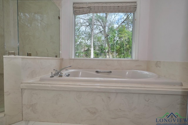 bathroom featuring a relaxing tiled tub