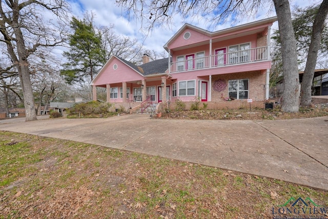 view of front of property featuring a balcony and covered porch