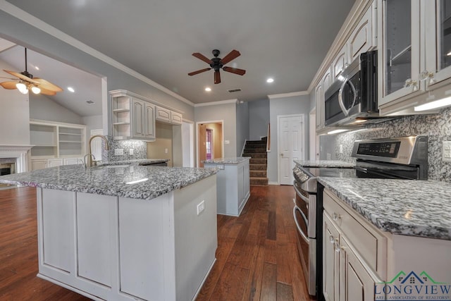 kitchen with stainless steel appliances, light stone countertops, sink, and dark hardwood / wood-style flooring