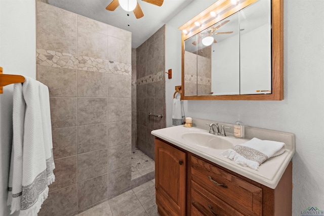 bathroom featuring a tile shower, ceiling fan, tile patterned flooring, and vanity