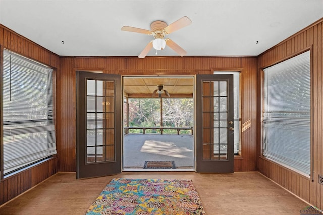 entryway with ceiling fan, french doors, and wood walls