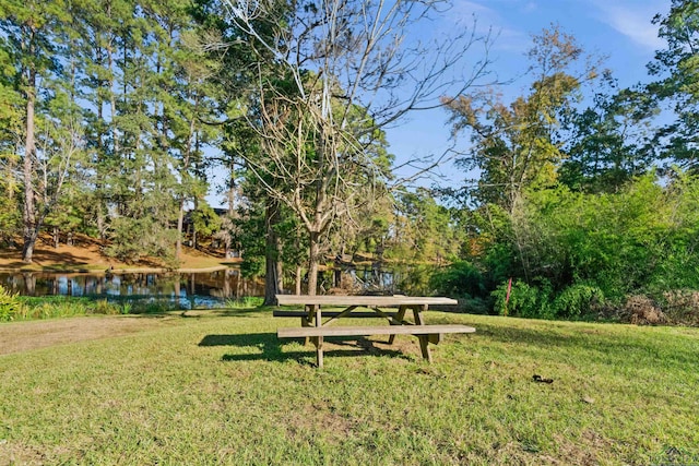 view of home's community with a yard and a water view