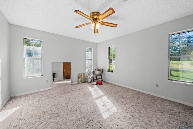 carpeted spare room featuring ceiling fan and a textured ceiling