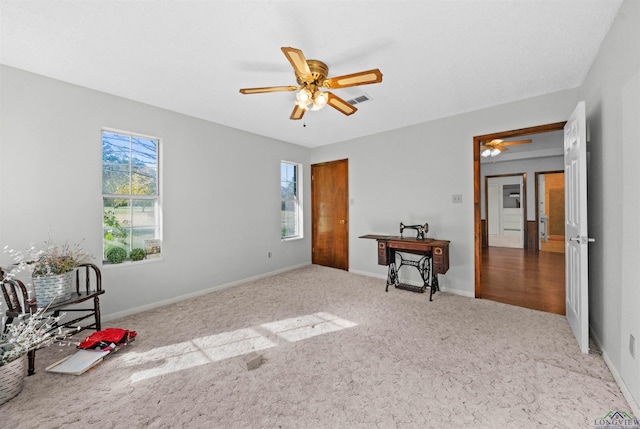 interior space featuring light carpet and ceiling fan