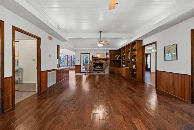 unfurnished living room with hardwood / wood-style floors and a stone fireplace