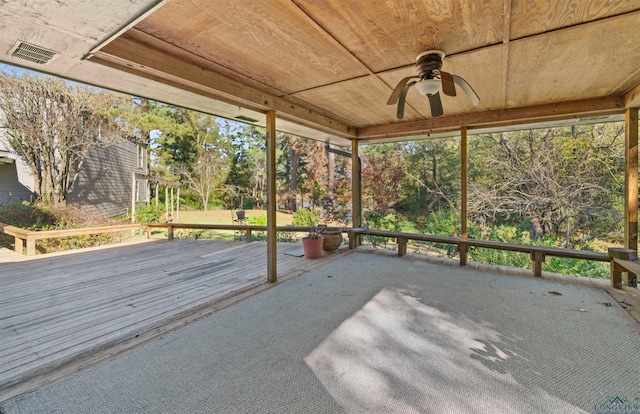 unfurnished sunroom with ceiling fan, a healthy amount of sunlight, and wood ceiling