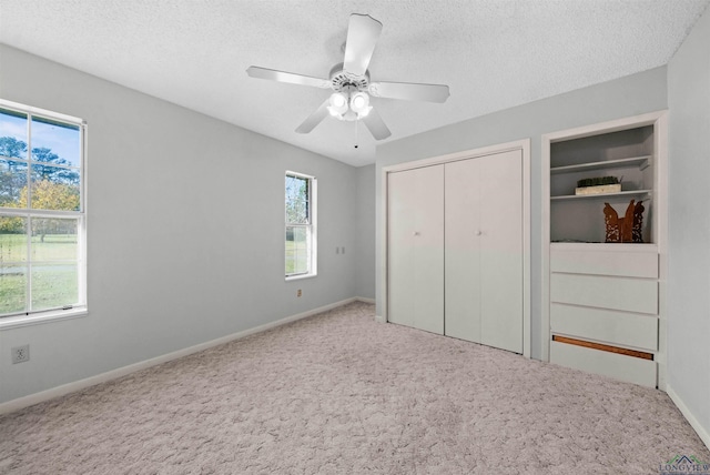 unfurnished bedroom with carpet, ceiling fan, and a textured ceiling