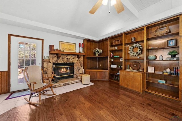 living area with ceiling fan, a fireplace, and hardwood / wood-style floors