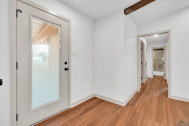 interior space featuring lofted ceiling with beams and light hardwood / wood-style floors